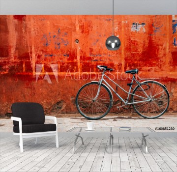 Picture of Old bike standing at colorful red wall